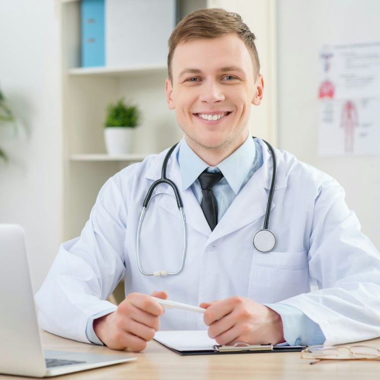 Sympathischer Arzt wartet am Computer auf die nächste Online-Sprechstunde bei TestoCare