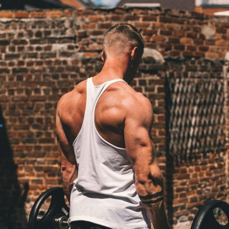 Durchtrainierter Mann im Tanktop von hinten – Symbol für Kraft, Muskeln und Erfolge der Testosterontherapie bei TestoCare
