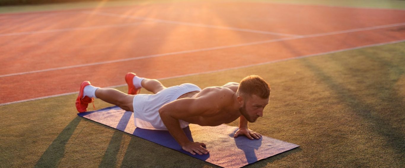 Fitness & Vitalität | TestoCare Testosterontherapie Online Sportlicher Mann macht oberkörperfrei Liegestütze am Tennisplatz bei Sonnenuntergang – Symbol für Stärke und Vitalität mit TestoCare