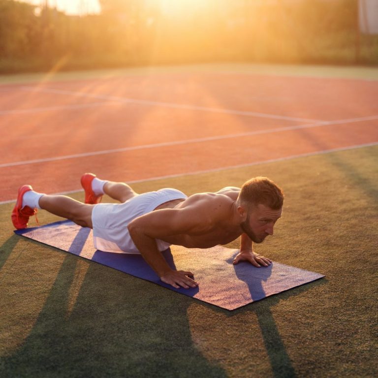Sportlicher Mann macht oberkörperfrei Liegestütze am Tennisplatz bei Sonnenuntergang – Symbol für Stärke und Vitalität mit TestoCare
